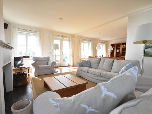 a living room with two couches and a coffee table at Beautiful villa on Terschelling in the dunes 150 meters away in Midsland aan Zee