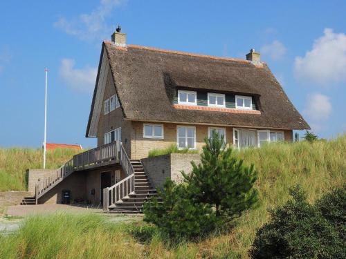 uma casa velha no topo de uma colina em Beautiful villa on Terschelling in the dunes 150 meters away em Midsland aan Zee