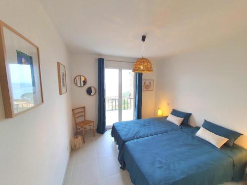 une chambre avec un lit bleu et une fenêtre dans l'établissement Domaine A Mortella T3, à Saint-Florent