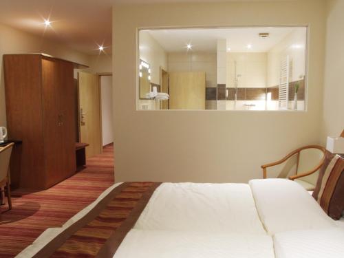 a hotel room with a bed and a mirror at Boutique Hotel Wolfsburg in Wolfsburg
