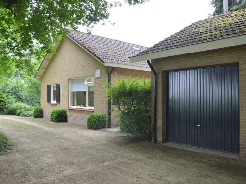 uma casa com uma porta de garagem ao lado dela em Rural holiday home wildlife spotting Achterhoek em IJzerlo