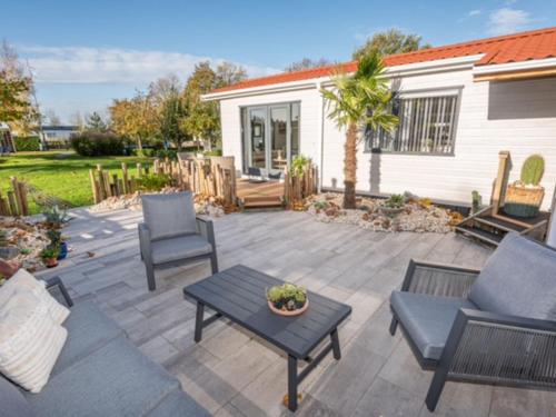 a patio with two chairs and a table at Chalet Sea Rocks with view and garden in Goedereede