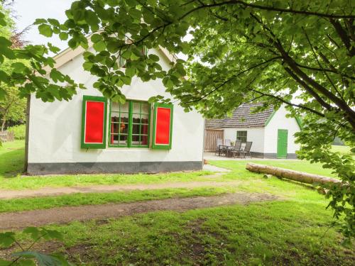 een huis met rode en groene ramen in een tuin bij Cozy Holiday Home near Forest in Baarn in Baarn