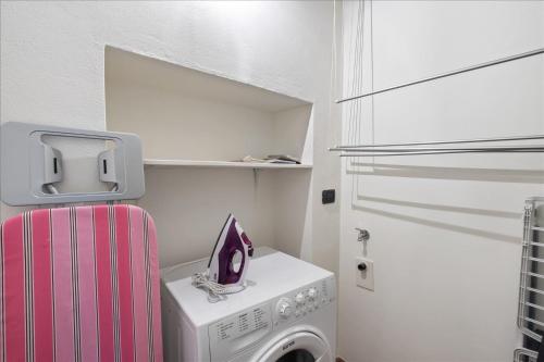 a small kitchen with a washing machine and a pink refrigerator at I Balconi in Iseo