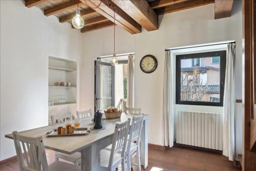 a kitchen with a table and chairs and a clock at I Balconi in Iseo