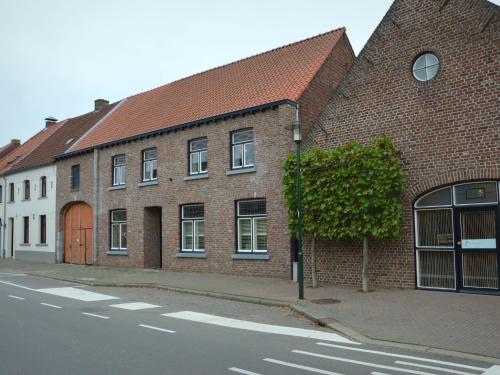 a brick building with a brown door on a street at Cozy apartment in Roasting near the Belgian border in Roosteren