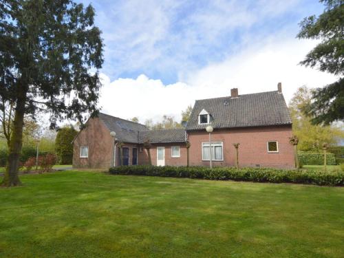 a large brick house with a grass yard at Lovely holiday home with lots of privacy in Valkenswaard
