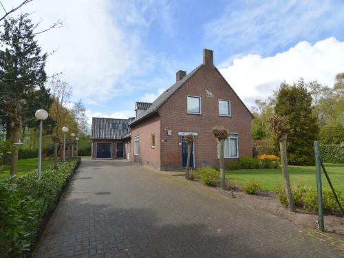 a red brick house with a driveway at Lovely holiday home with lots of privacy in Valkenswaard