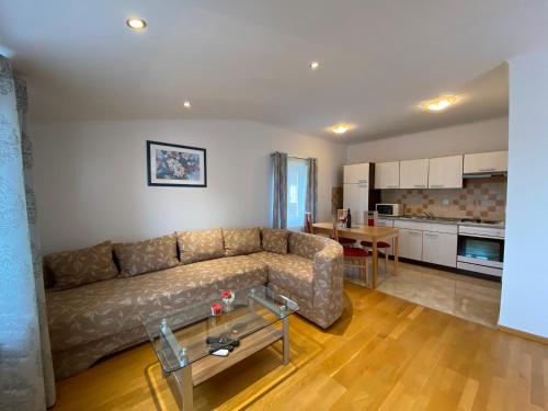 ein Wohnzimmer mit einem Sofa und einer Küche in der Unterkunft Apartments Gajić in Fažana