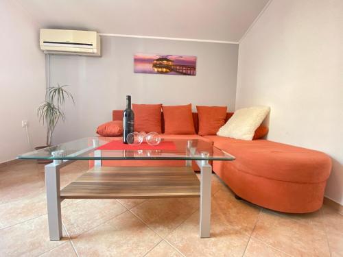 uma sala de estar com uma mesa de vidro e um sofá em Apartments Gajić em Fažana
