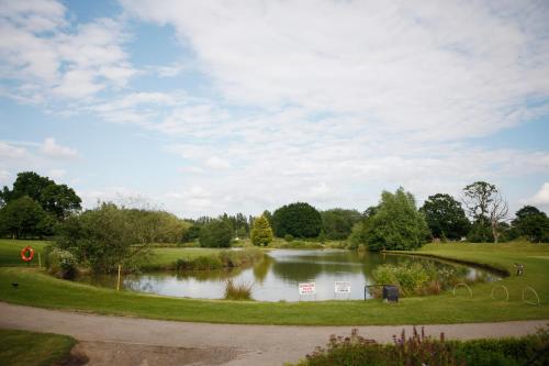 a pond in the middle of a park at Weald of Kent Golf Course and Hotel in Maidstone