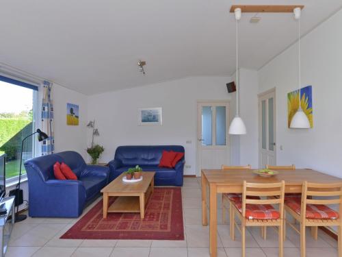 ein Wohnzimmer mit einem blauen Sofa und einem Tisch in der Unterkunft Detached bungalow close to Lake Veere in Kamperland