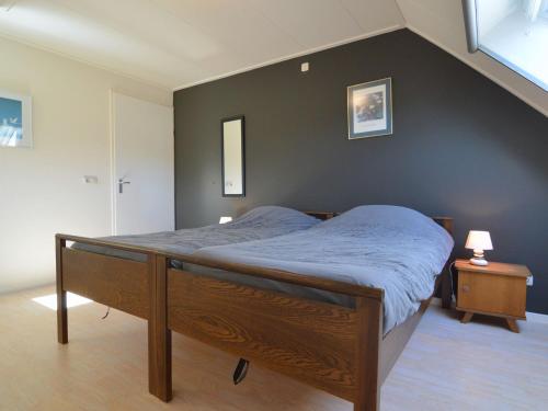 Ce lit se trouve dans une chambre dotée d'un mur noir. dans l'établissement Quaint Farmhouse in Haarlo near the Forest, à Haarlo