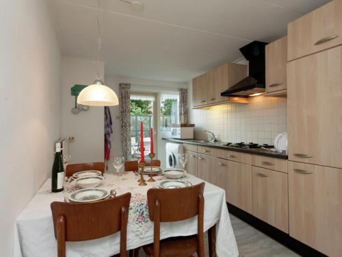 a kitchen with a table with chairs and a dining room at Fairytale Cottage in Nes Friesland with garden in Nes