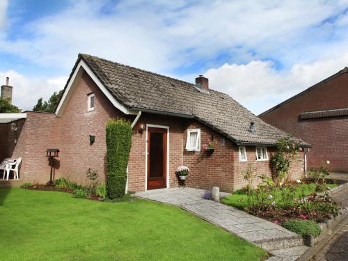 a red brick house with a grass yard at Tranquil Holiday Home in Margraten in Margraten