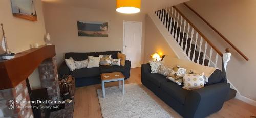 a living room with two couches and a staircase at Hartendale in Flamborough