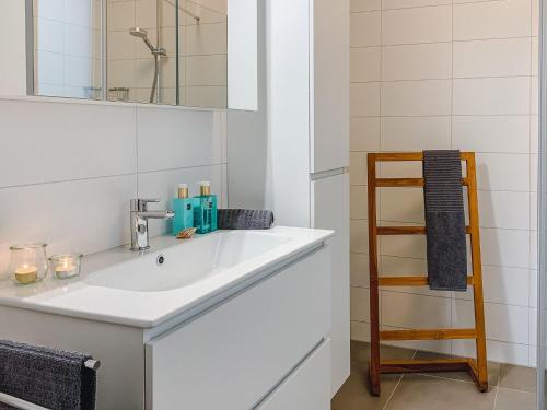 ein Badezimmer mit einem weißen Waschbecken und einer Holzleiter in der Unterkunft Elegant Holiday Home in Kamperland next to the Lake in Kamperland