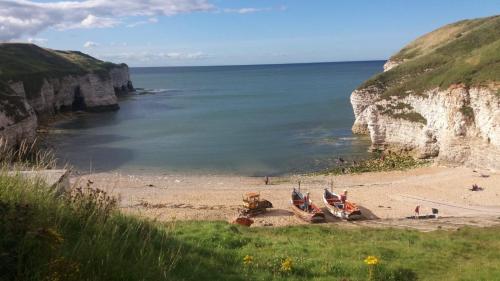 a sandy beach with two flags on it next to the ocean at Hartendale in Flamborough
