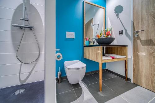 a bathroom with a toilet and a sink and a mirror at Résidence Santa Apolonia in Saint-Leu