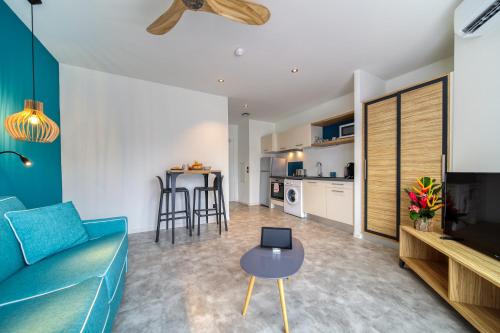 a living room with a blue couch and a table at Résidence Santa Apolonia in Saint-Leu
