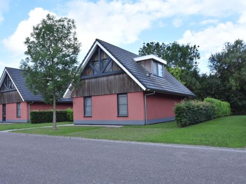 una casa roja con techo negro en Comfortably vacation home at Slotermeer Lake, en Balk
