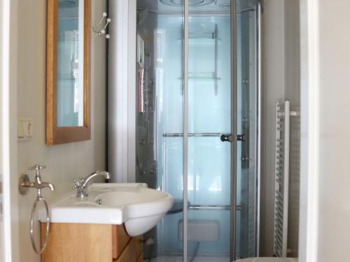 Un baño con lavabo y ducha de cristal. en Luxury VOC Stay w Views, en Enkhuizen