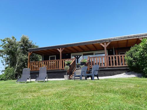 een huis met stoelen in het gras bij Fantastic brand new vacation home near the Wadden in Paesens