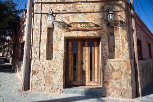 a stone building with a sign above a door at Hotel Norte Rupestre in Tilcara