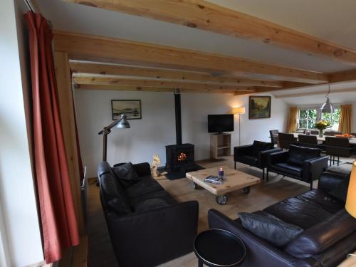 a living room with leather furniture and a fireplace at Nice holiday home on the Dutch coast with terrace in Nieuwvliet