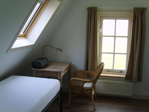 HippolytushoefにあるCozy villa with garden, close to the Wadden Seaのベッドルーム1室(ベッド1台、デスク、窓付)