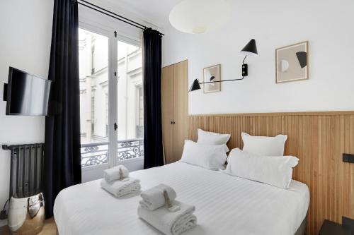 une chambre avec un lit avec deux serviettes dessus dans l'établissement Pick A Flat's Apartments in Opéra - Rue de Richelieu, à Paris