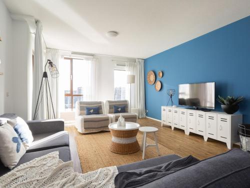 ein blaues Wohnzimmer mit einem Sofa und einem TV in der Unterkunft Luxury apartment fantastic view of the marina in Scheveningen in Scheveningen