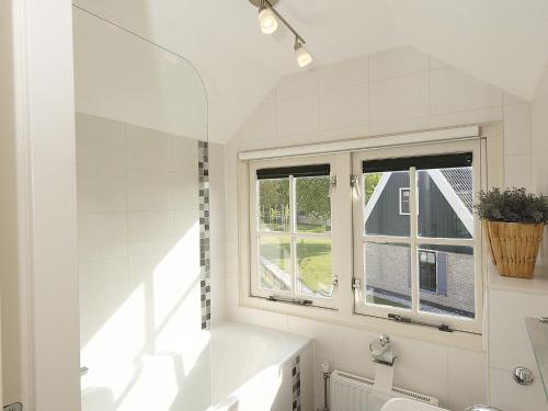 HippolytushoefにあるCozy villa in Wieringer style near the Wadden Seaの白いバスルーム(シンク、窓付)