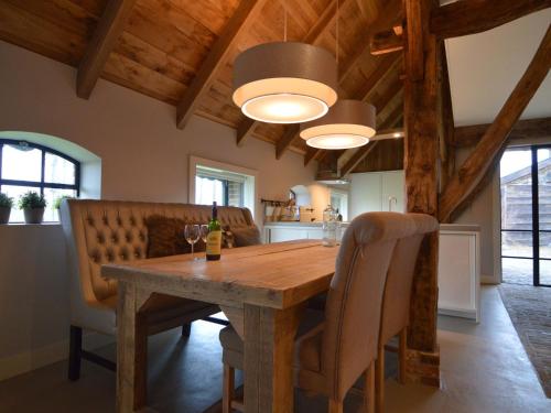 uma sala de jantar com uma mesa de madeira e cadeiras em Stylish Farmhouse in Nieuwleusen with Private Garden and Sauna em Nieuwleusen