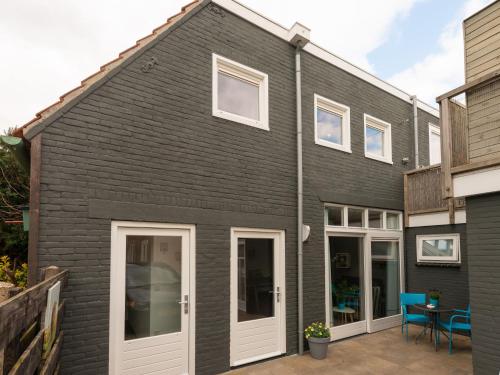 スコールルにあるApartment in Schoorl near Dunesの白いドアとパティオのある黒い家