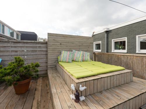 スコールルにあるApartment in Schoorl near Dunesの木製デッキ(緑のベッド付)