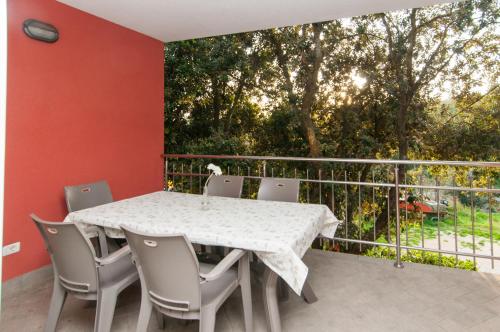 un tavolo bianco e sedie su un balcone con un albero di SeaHouse 114 a Mali Lošinj (Lussinpiccolo)