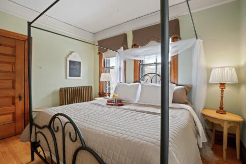 een slaapkamer met een groot bed met een baldakijn bij Historic District BnB in Saint Paul