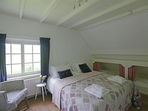 ein Schlafzimmer mit einem Bett, einem Stuhl und einem Fenster in der Unterkunft Peaceful Farmhouse in Doorn near Forest in Doorn