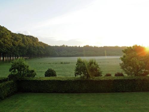 a view of a grassy field with trees and the sunset at Peaceful Farmhouse in Doorn near Forest in Doorn