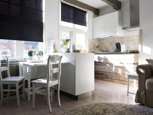 a kitchen with white cabinets and a table and chairs at Boutique Holiday Home in Middelburg with Roof Terrace in Middelburg