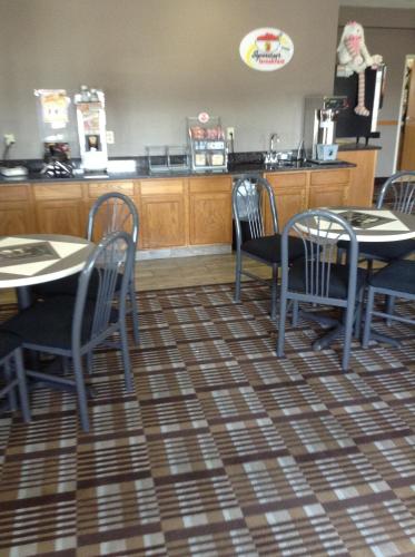 a restaurant with tables and chairs and a counter at Super 8 by Wyndham Carroll/East in Carroll