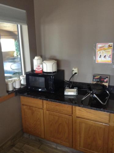a kitchen counter with a coffee maker and a microwave at Super 8 by Wyndham Carroll/East in Carroll