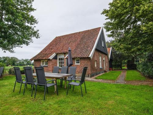 a table and chairs in front of a brick house at Farmhouse in Enschede near Forest in Enschede