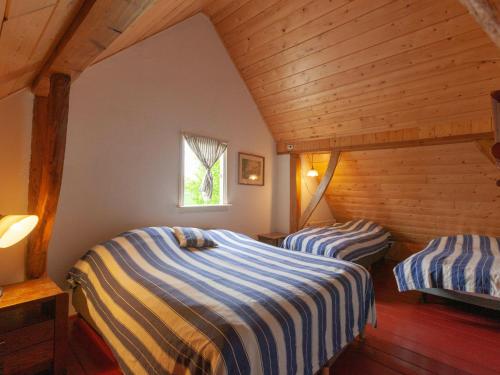 two beds in a room with wooden ceilings at Farmhouse in Enschede near Forest in Enschede