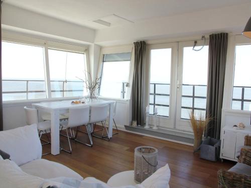 a living room with a white table and some windows at Heritage Holiday Home in Huisduinen near Sea in Huisduinen