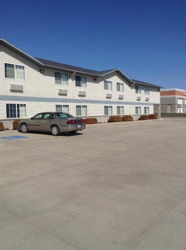 a car parked in a parking lot in front of a building at Super 8 by Wyndham Carroll/East in Carroll