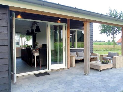 an extension to a patio with sliding glass doors at Lovely cottage in the middle of nature in Keijenborg