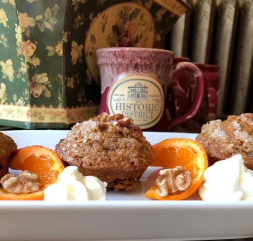 a plate of muffins and oranges and a cup of coffee at Historic District BnB in Saint Paul