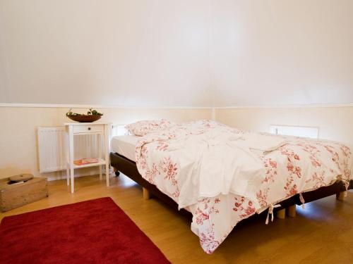 a bedroom with a bed and a red rug at Stylish Farmhouse Escape in Wierden